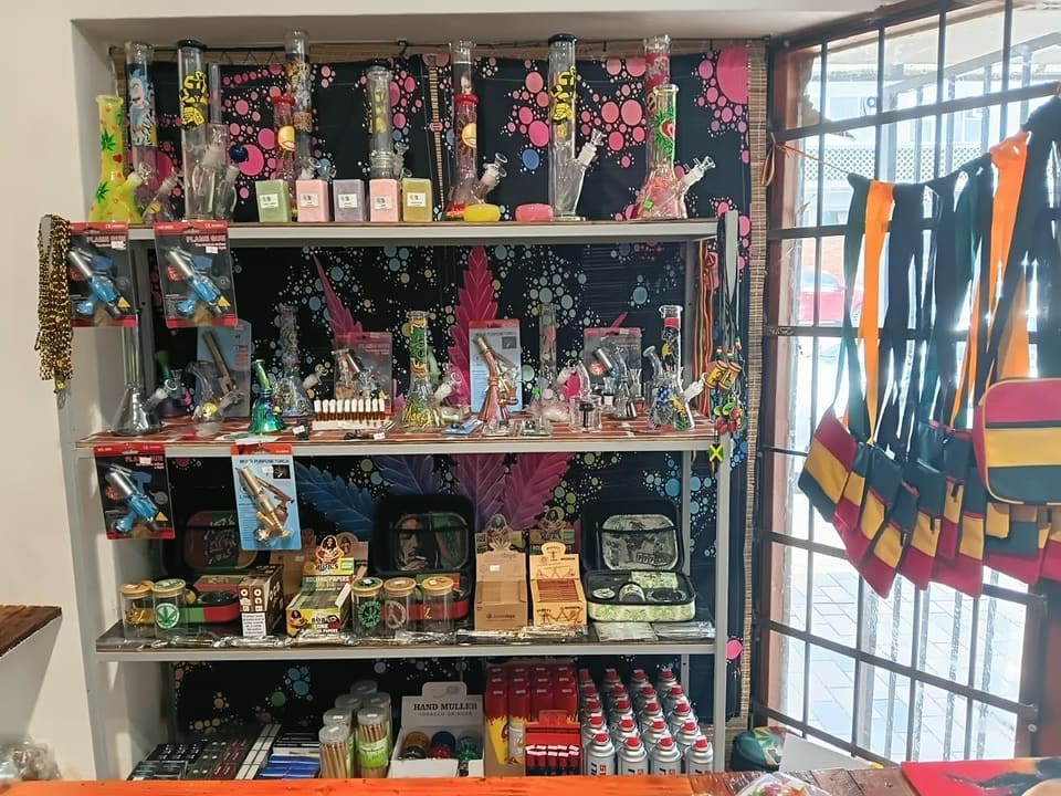 Shelf of glass water pipes, hand pipes and colourful accessories at the shop