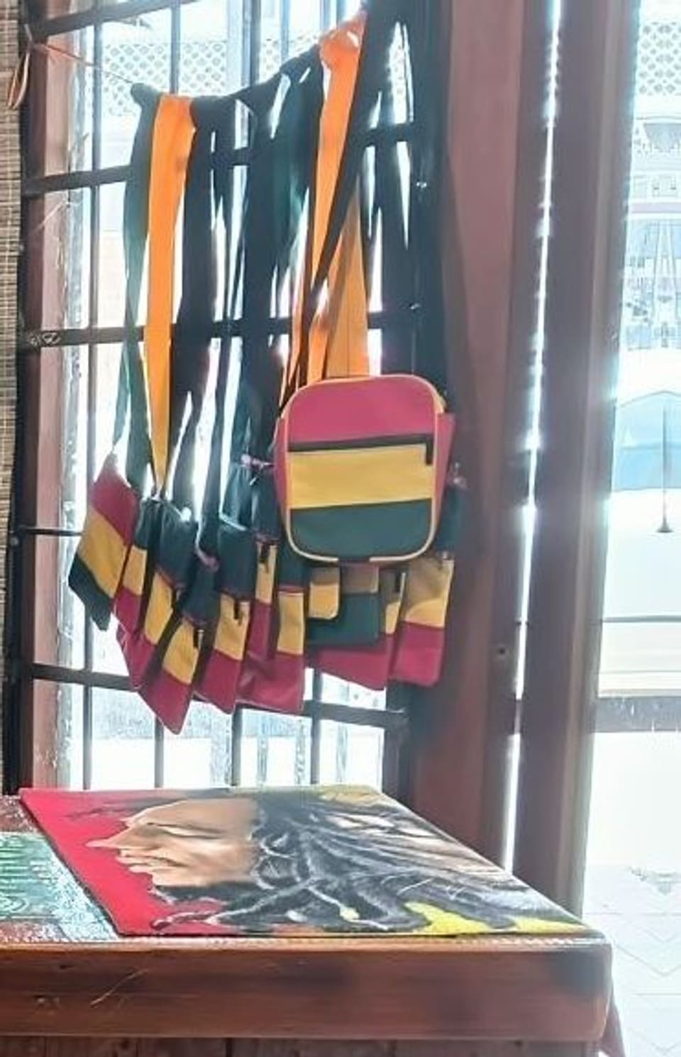 Rasta-coloured shoulder bags hanging in the shop doorway
