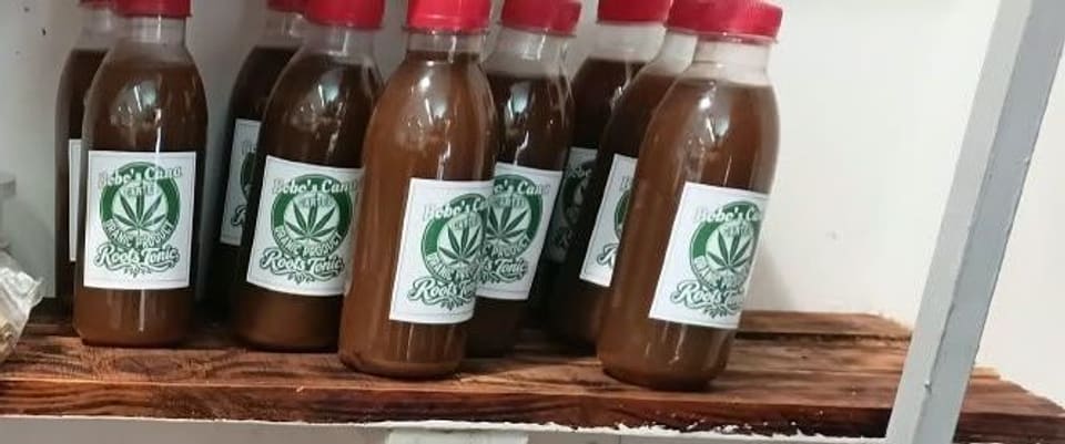 Rows of Bobo's Cana Cartel Roots Tonic bottles on the top shelf